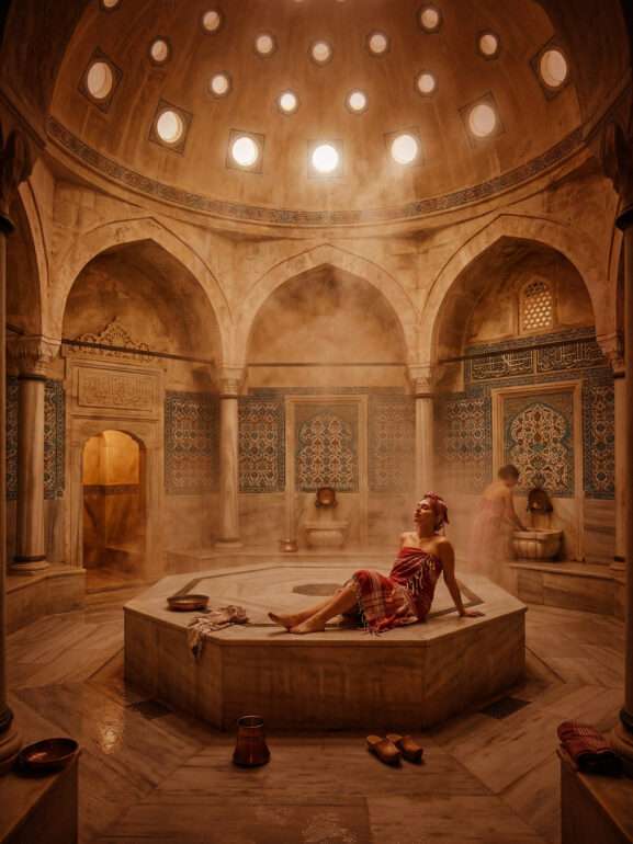 Woman with a Beauty & Care pestemal sitting in a hamam.